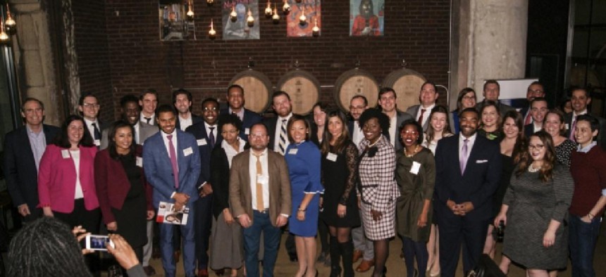 The honorees assembled for a group shot in front of the brew house's kegs