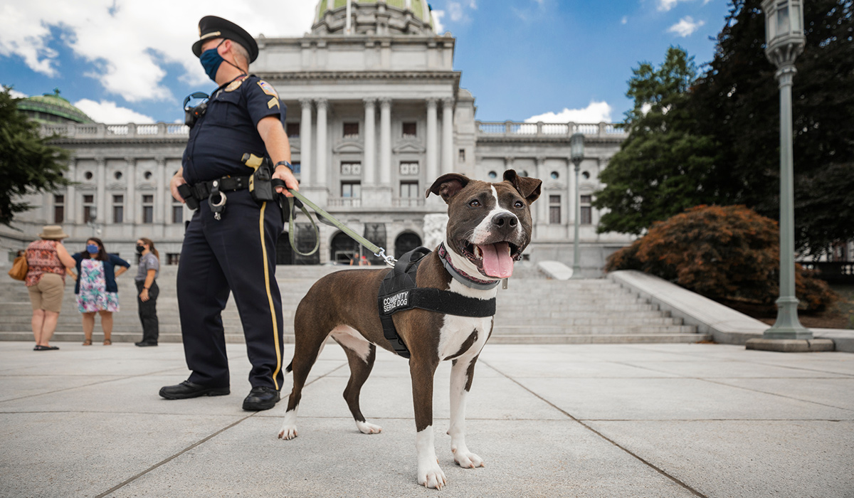 State Police Sgt. Mike Schmidt stands with Cappy, the Capitol Police Public service dog. 