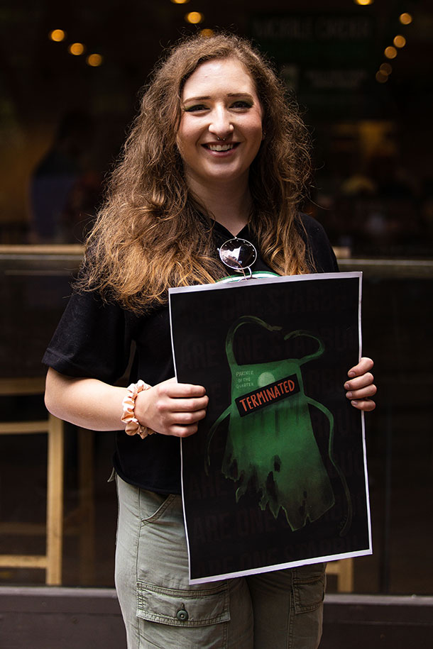 Former Starbucks shift manager, Tori Tambellini, of Pittsburgh's Market Square Starbucks poses with a poster after two workers were fired for trying to unionize.