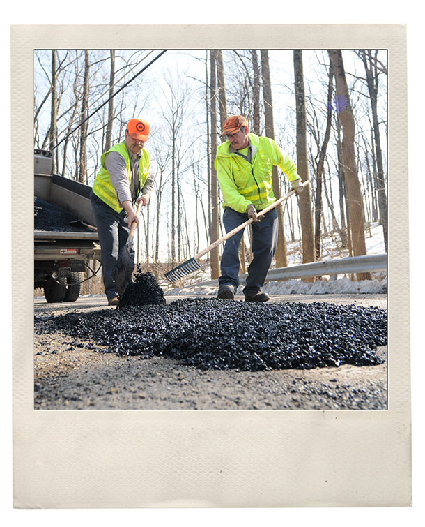 Cumru Township road crew workers patch a pot hole on Ledgerock Rd. in the township.