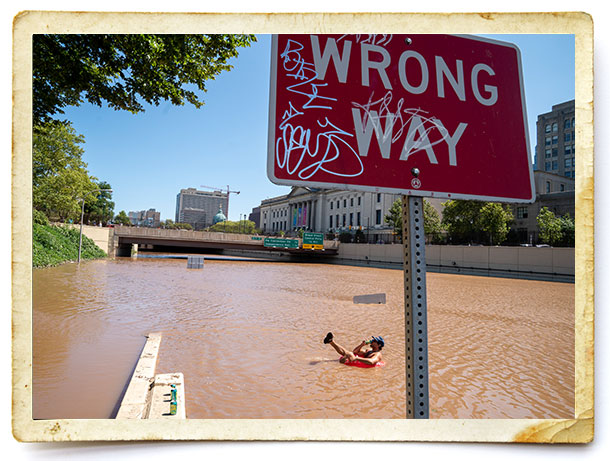 Austin Ferdock drinks a beer while floating in remnants of Hurricane Ida on Sept. 2, 2021.