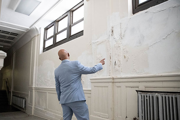 Hughes surveys the inside of a Philadelphia school building, looking for potential safety hazards.