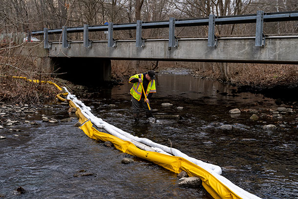 Ron Fodo of Ohio EPA looks for signs of fish by agitating the water in Leslie Run Creek.