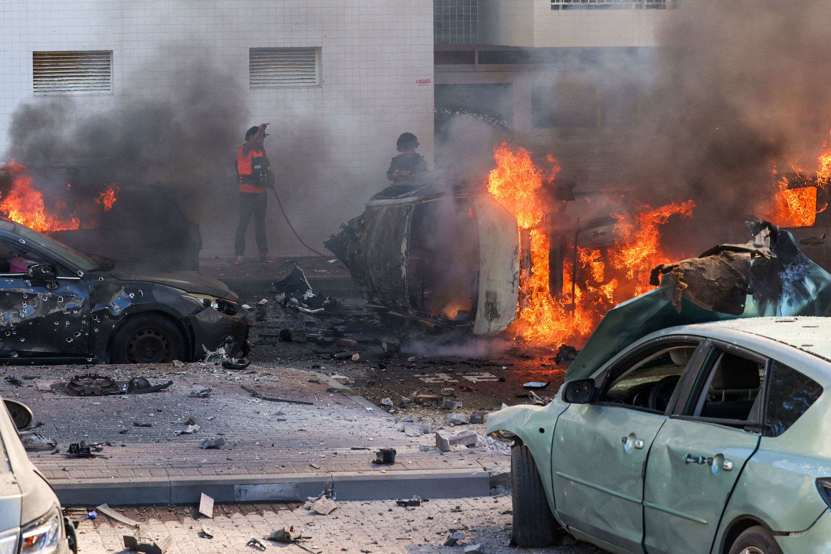 People try to put out fires following a rocket attack that came from the Gaza Strip in southern Israel.