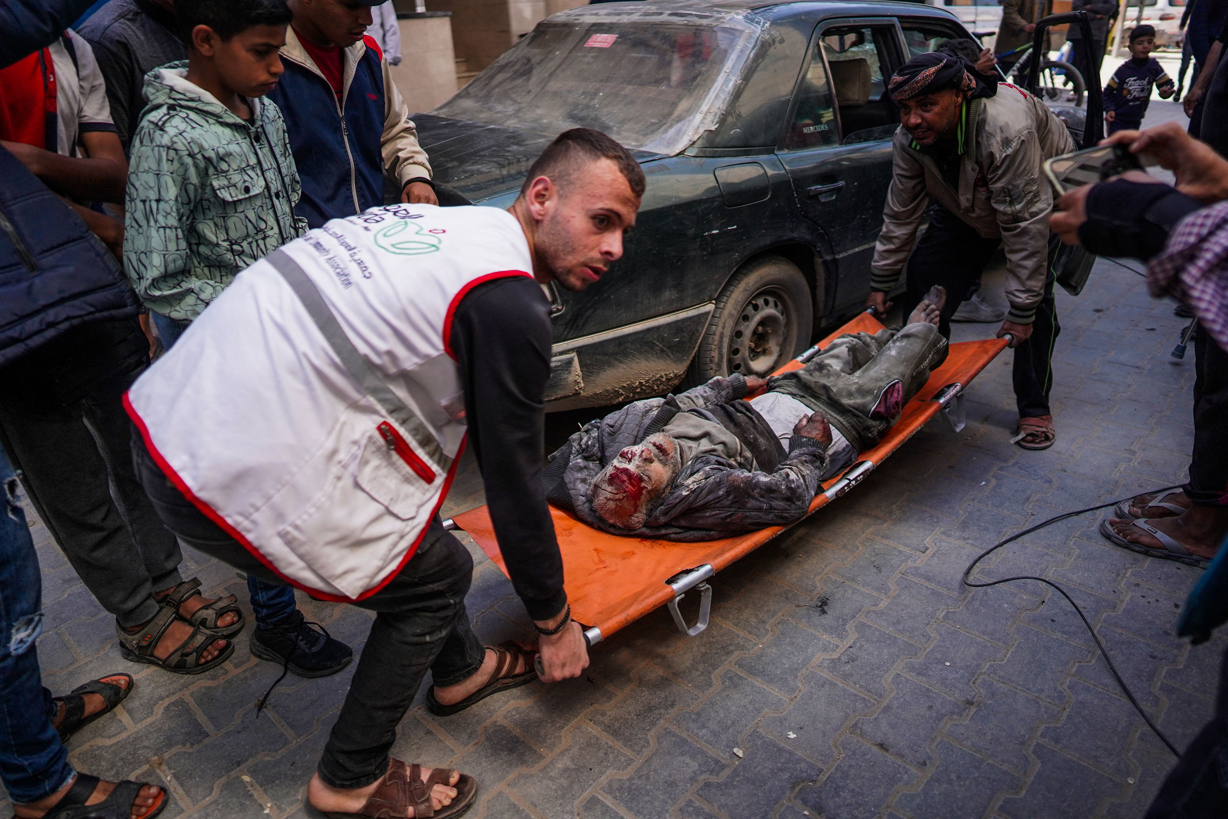 A man and a paramedic carry an injured man on a stretcher following Israeli bombardment in Nuseirat, central Gaza.