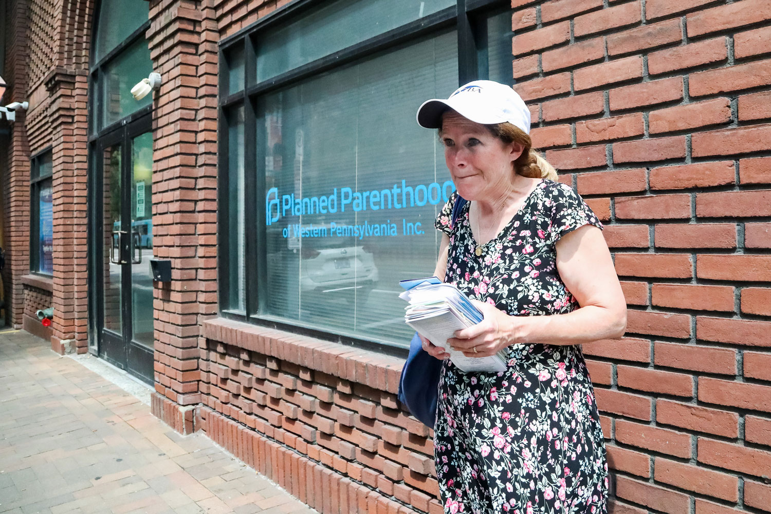 A woman holding anti-abortion pamphlets stands outside Planned Parenthood of Western Pennsylvania.