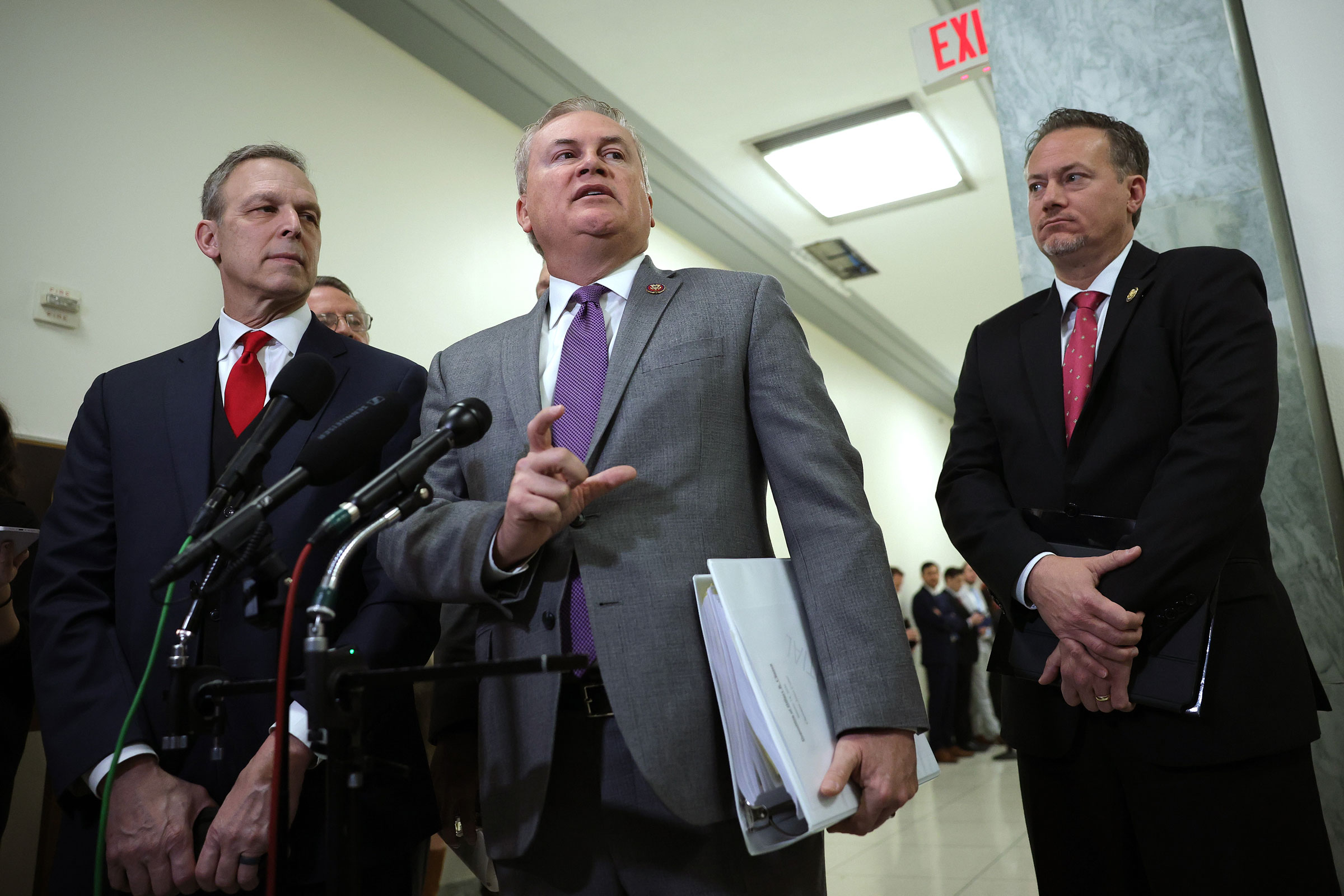 Perry, left, watches as U.S. Rep James Comer speaks to the media.