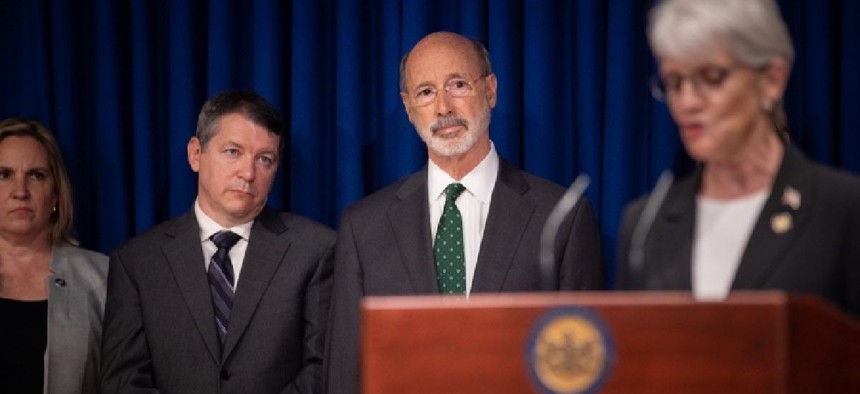 Gov. Tom Wolf looks on as state Sen. Carolyn Comitta speaks about RGGI.