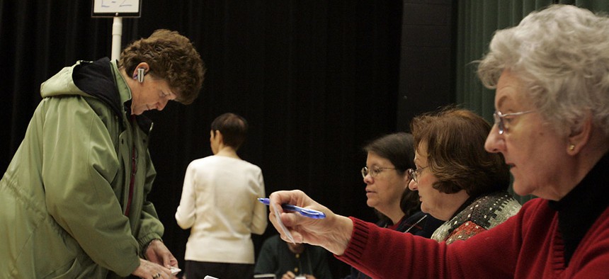 A poller worker in Virginia checks a person’s ID. Virginia is one of 35 states that require voters to provide an acceptable form of ID when voting in person.