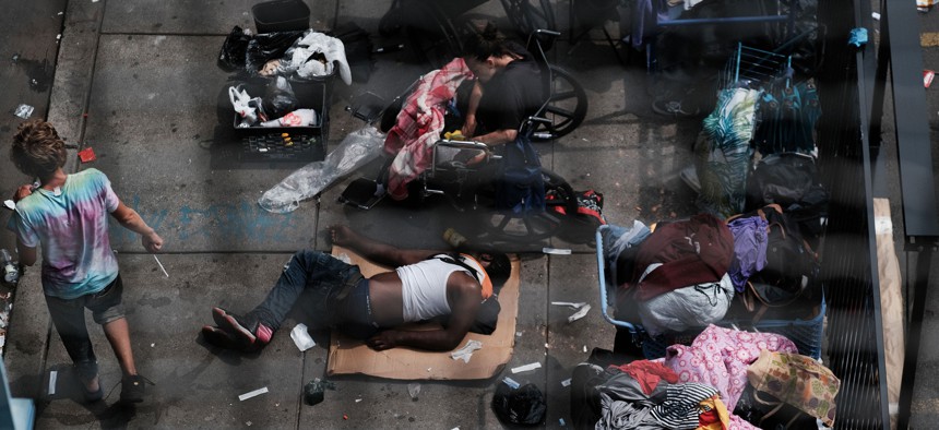 People gather on a street overtaken by heroin users in the Philadelphia neighborhood of Kensington in 2021.