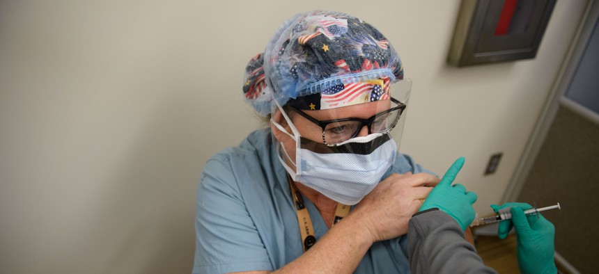 Nurse Anesthetist Sally Ollio receives a COVID-19 vaccine at the Pittsburgh VA Medical Center on December 17, 2020